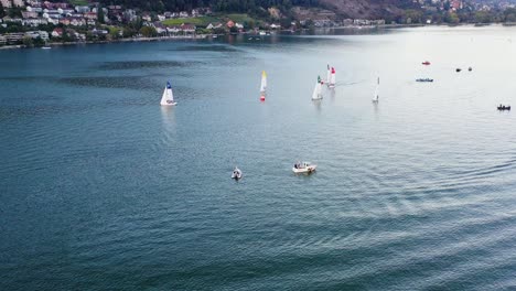 aerial drone footage following a motor boat approaching sailboats on lake biel and showing off the blue waters and gorgeous scenery