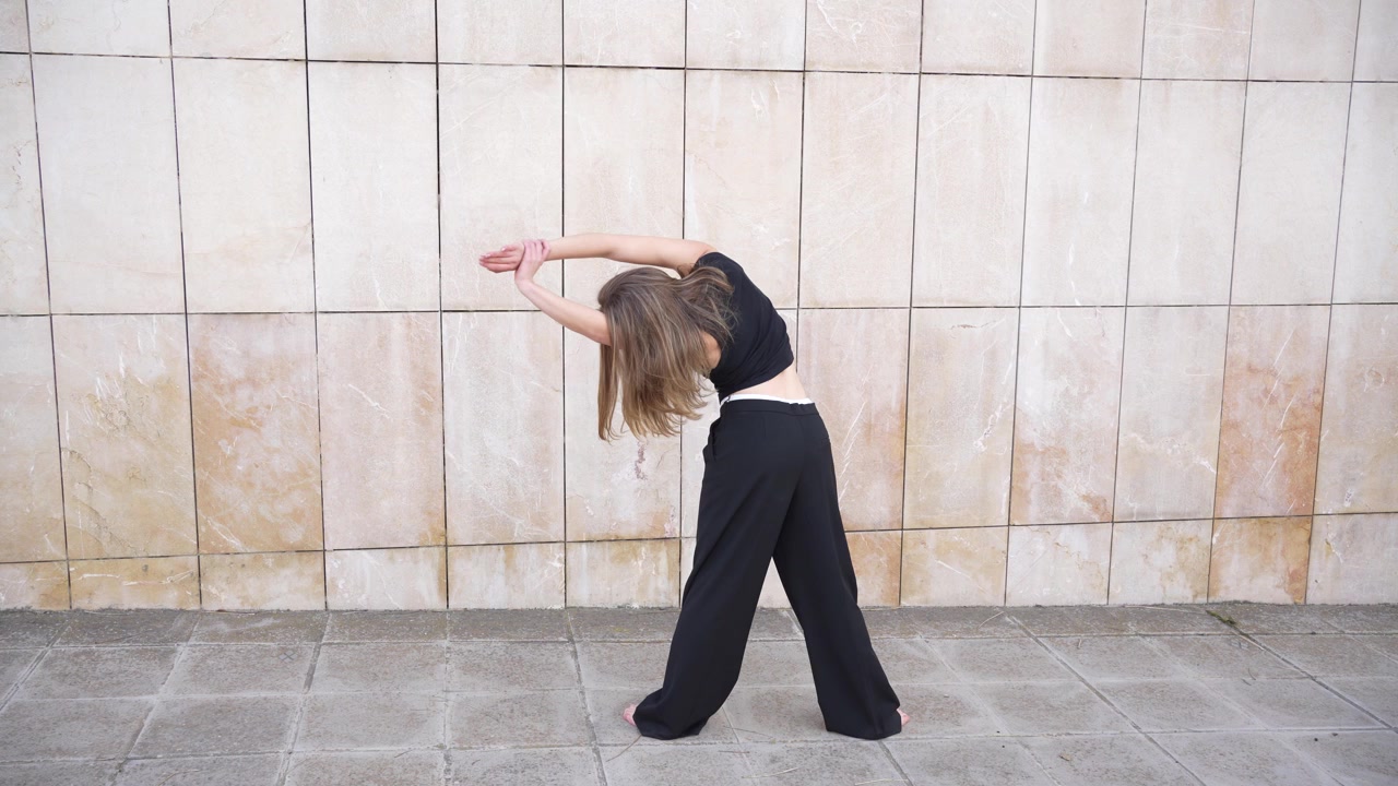 Engaging in dynamic movement and stretching practice against a textured wall environment
