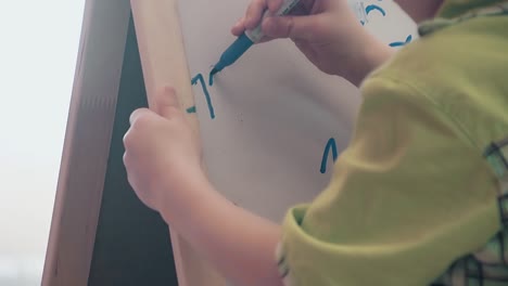 schoolboy writing numbers on the blackboard