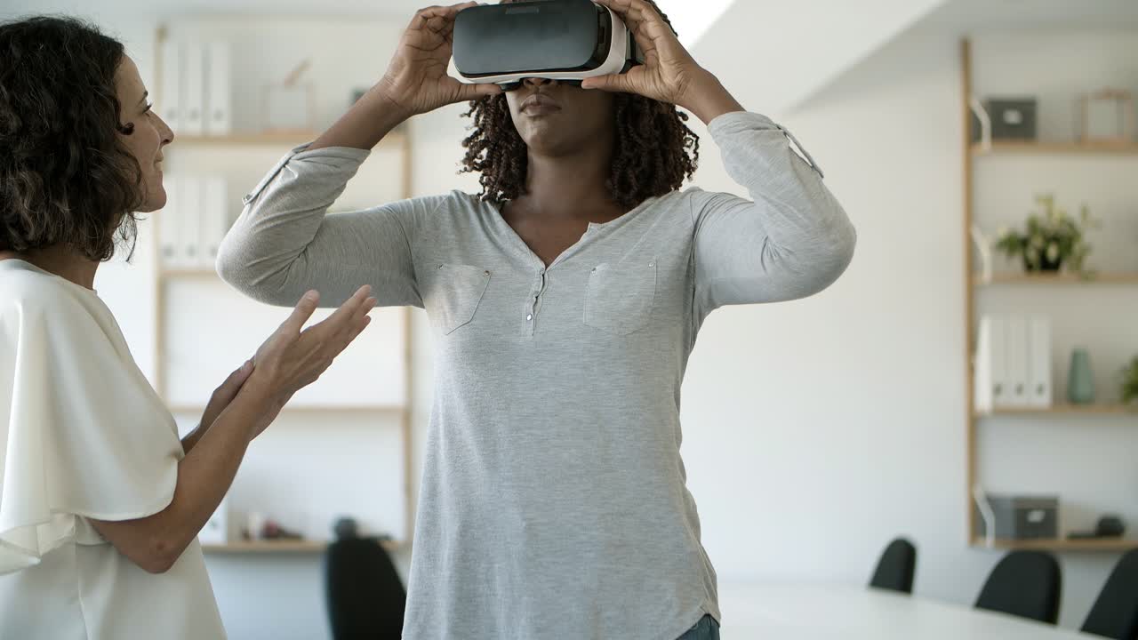 Front view of excited woman testing VR headset with assistant
