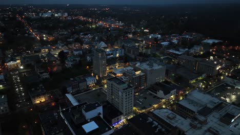 aerial top down shot of lighting city of america at night. warm lighting streetlamps in downtown with towers and residential area. wide shot.