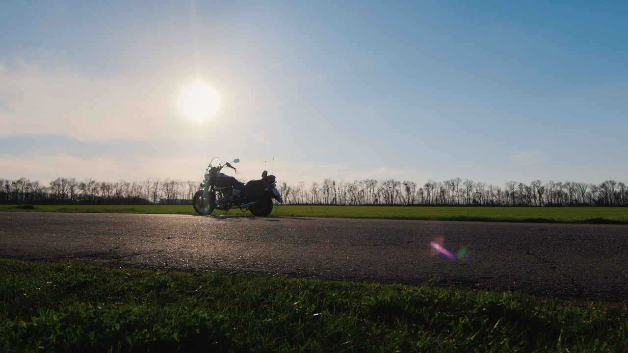 손에 헬멧을 들고 꿈을 꾸고 여행하는 바이커는 오토바이 hd 비디오로 이동합니다.