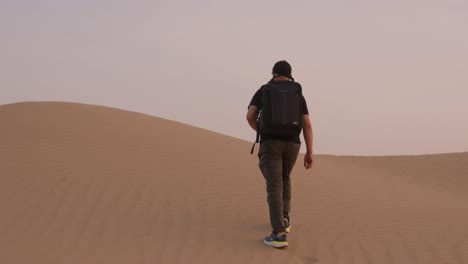 fotógrafo solitario caminando en el desierto tomando fotografías en la cámara zenit de la antigua era soviética