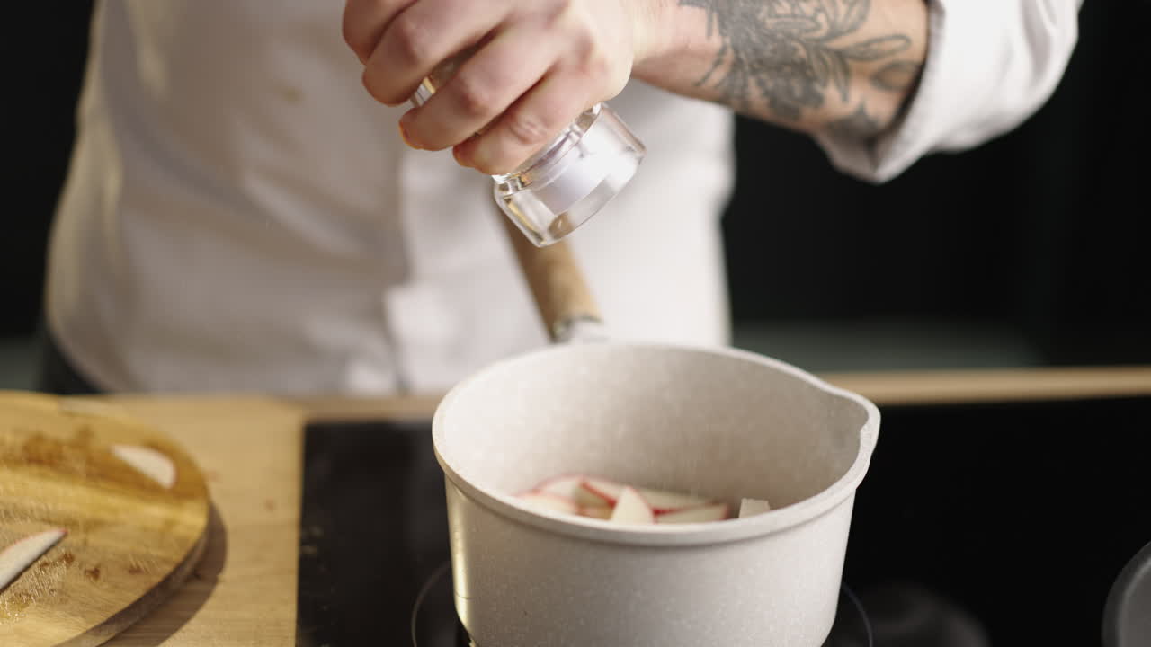 Adding salt to apple slices in a pot