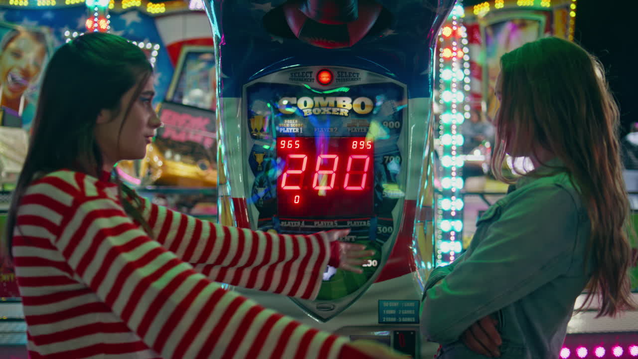 Best friends enjoying amusement park weekend. Smiling girl comforting girlfriend