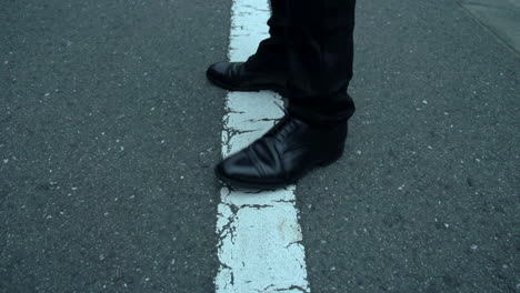 worried man in black waits on the street