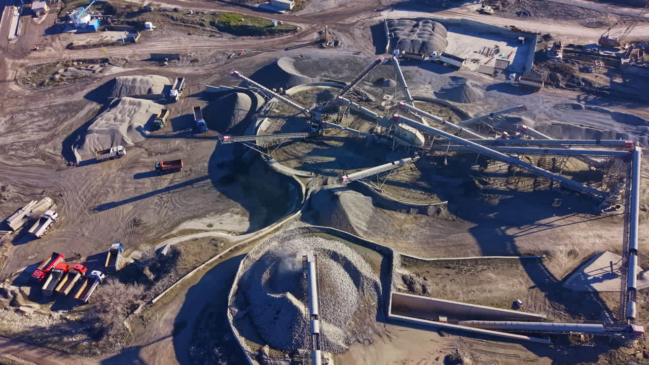 Construction site showing active machinery and material movement in an industrial area during daylight hours
