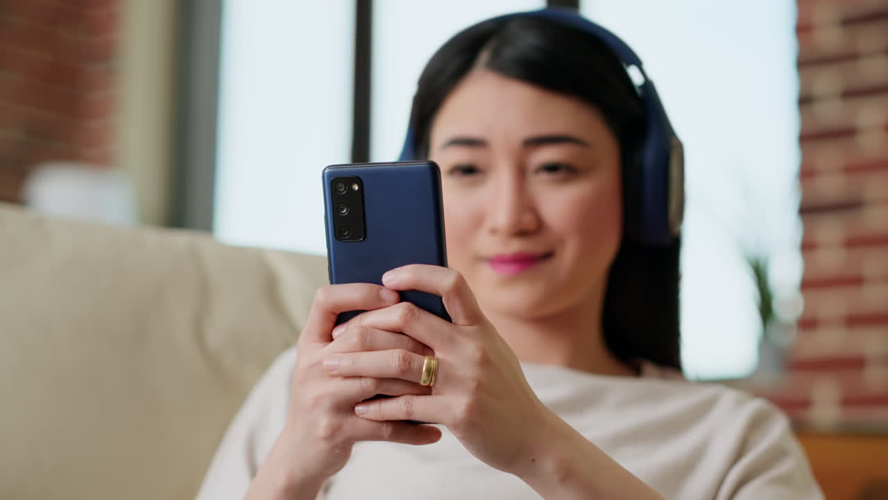 Woman enjoying content on mobile phone with headphones