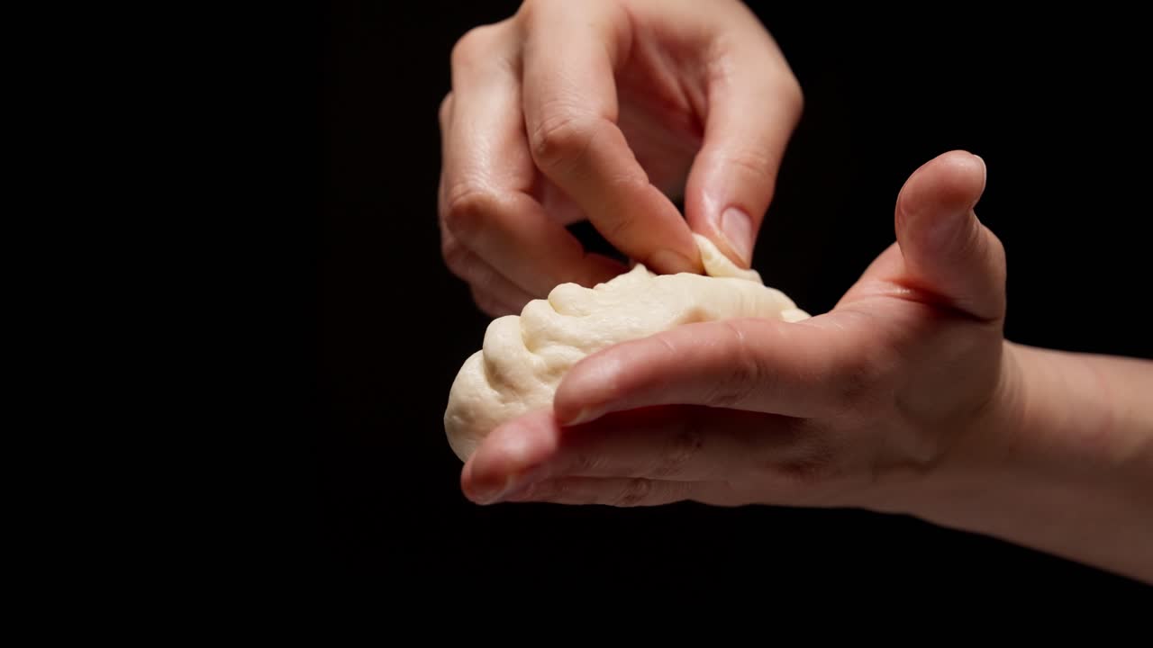 餃子を作るために生地をひだ状にしている手元のクローズアップ