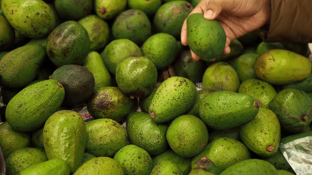 mujeres jóvenes con la mano de aguacate comprando en una tienda minorista