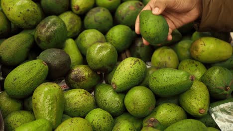 Junge-Frauen-Halten-Avocado-In-Der-Hand-Und-Kaufen-Im-Einzelhandelsgeschäft-Ein