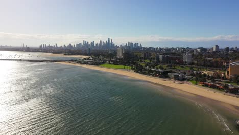 Imágenes-Aéreas-Sobre-Los-Mares-De-La-Playa-De-St-Kilda,-Con-El-Horizonte-Del-CDB-De-Melbourne-En-El-Horizonte-En-Una-Hermosa-Tarde-Ventosa-De-Otoño