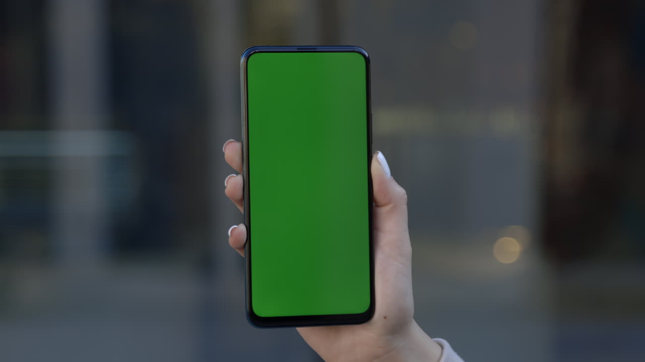 mano sosteniendo un teléfono inteligente con una pantalla verde