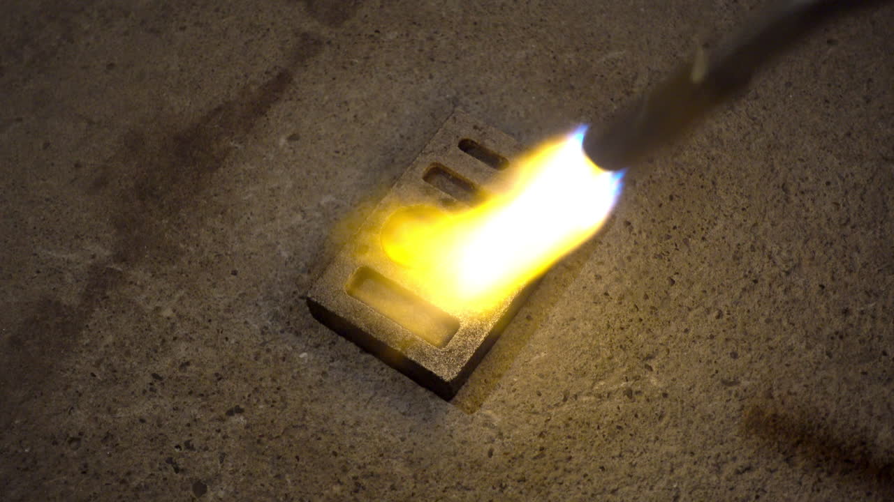 Torch heats ingot mold before pouring molten metal
