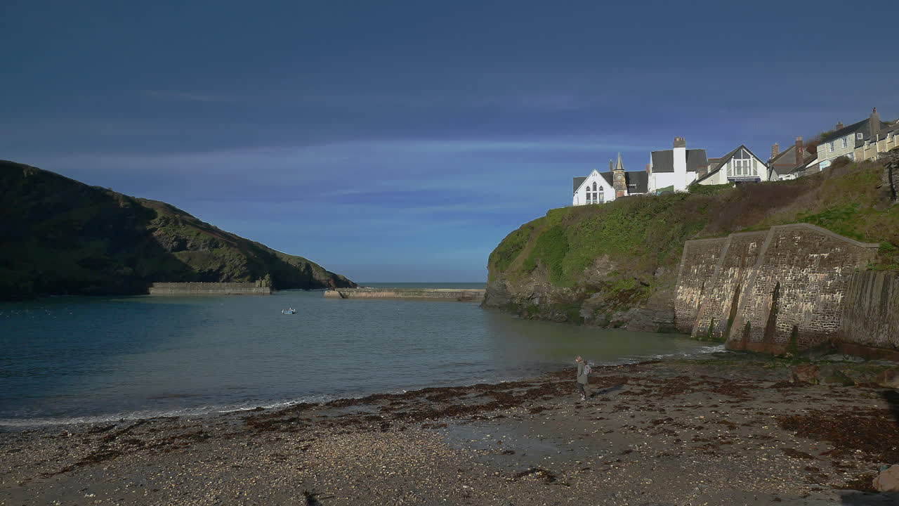 A lone person walking on the beach at Port isaac in Cornwall