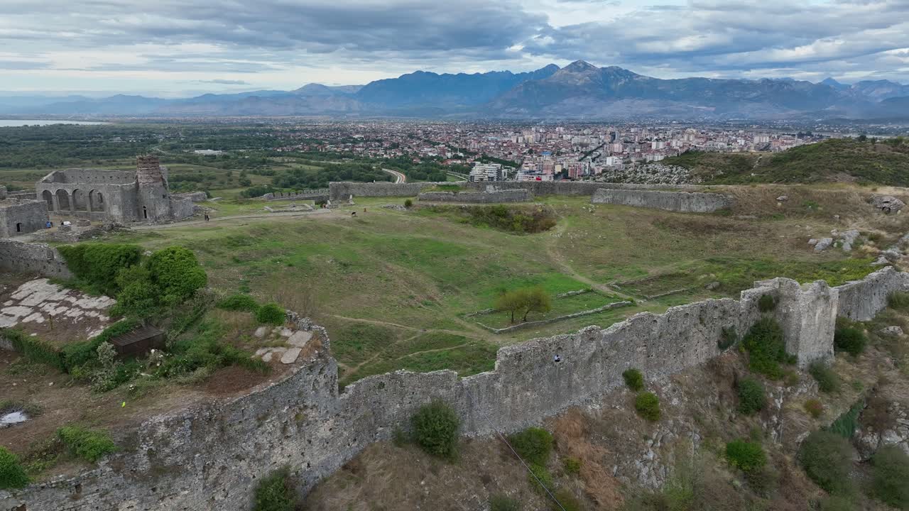Antiche rovine e la città di Scutari con montagne distanti sullo sfondo, vista aerea.