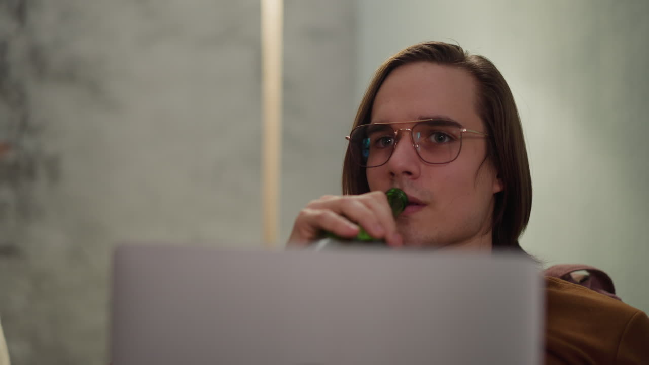 hombre hipster con computadora portátil bebiendo cerveza viendo un juego de hockey