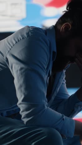 vertical video young man stares at smartphone in distress symbolizing toxic impact