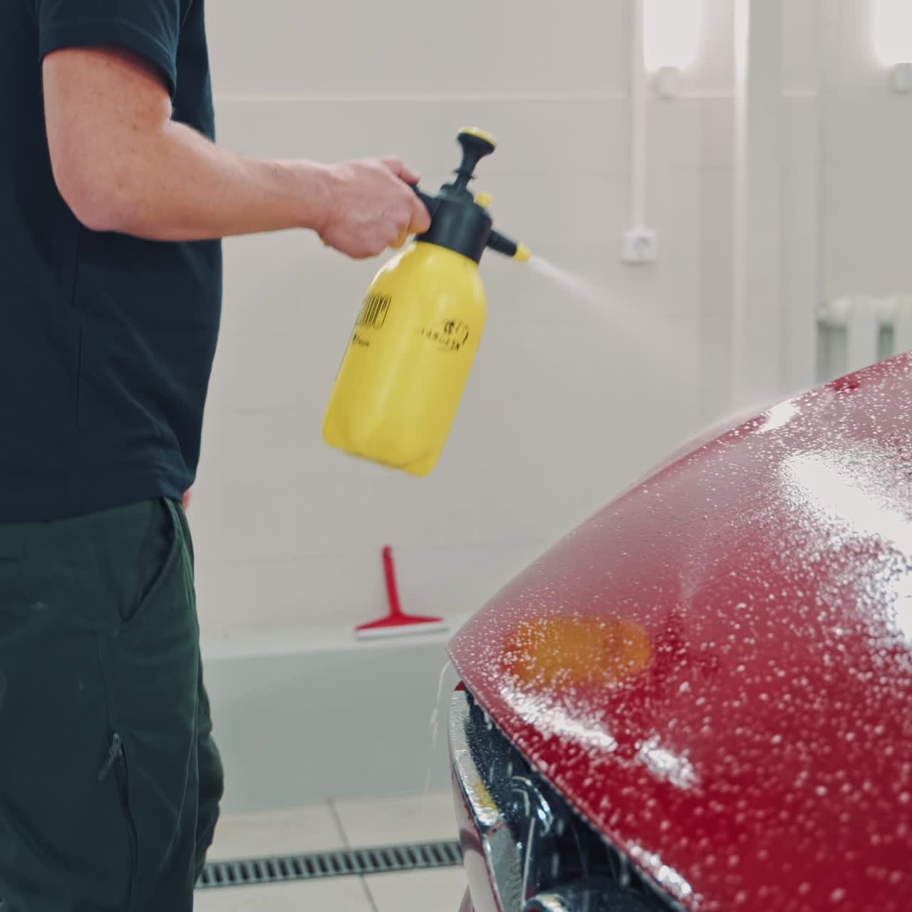 Man cleaning red Tesla