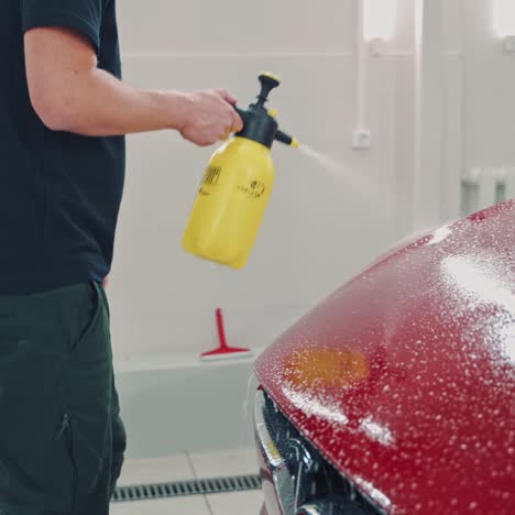 man cleaning red tesla