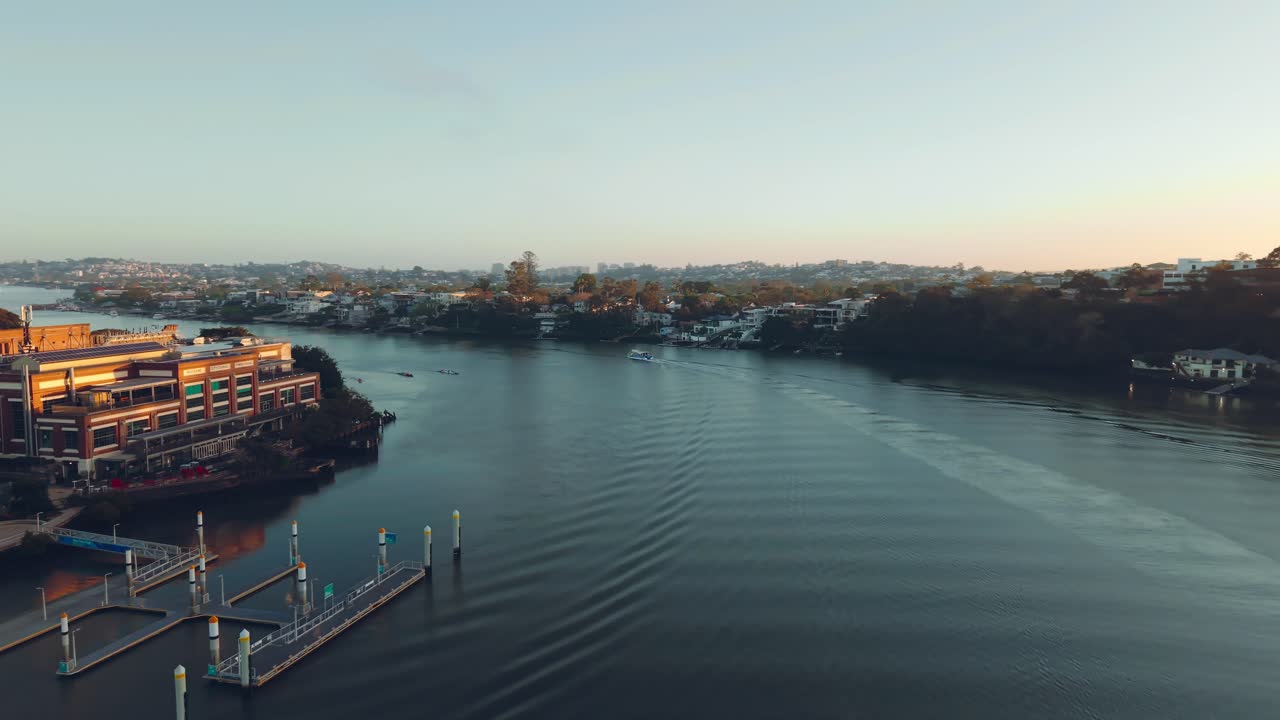 Um drone segue um barco no rio Brisbane, próximo a Teneriffe, mostrando as pontes e a costa, Queensland, Austrália