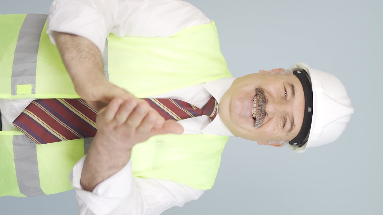 vídeo vertical del viejo ingeniero aplaudiendo con entusiasmo.