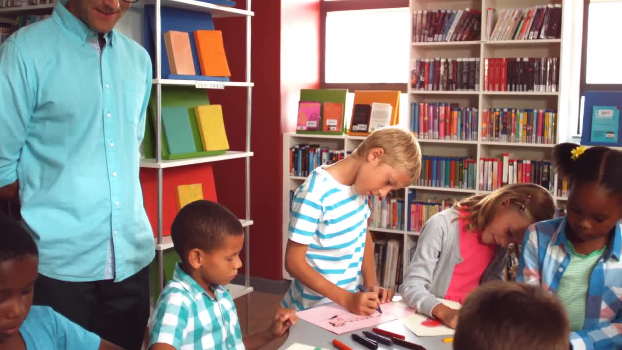 maestro ayudando a los niños con su tarea en la biblioteca