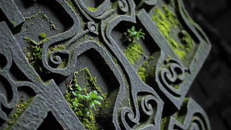 intricate stone carving covered in moss