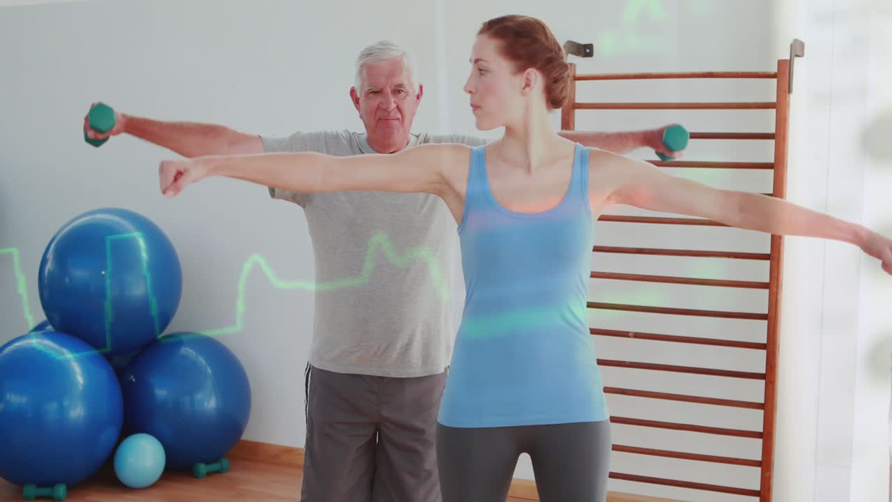 Coach starting arm raises, client copying, aiding shoulder rehab with green weights and ECG overlay