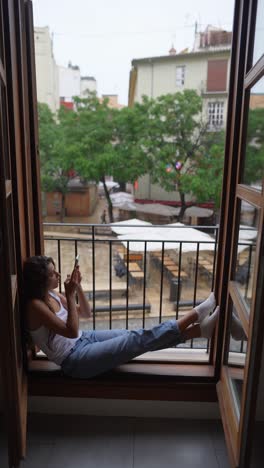 young woman relaxing at the window on a rainy day