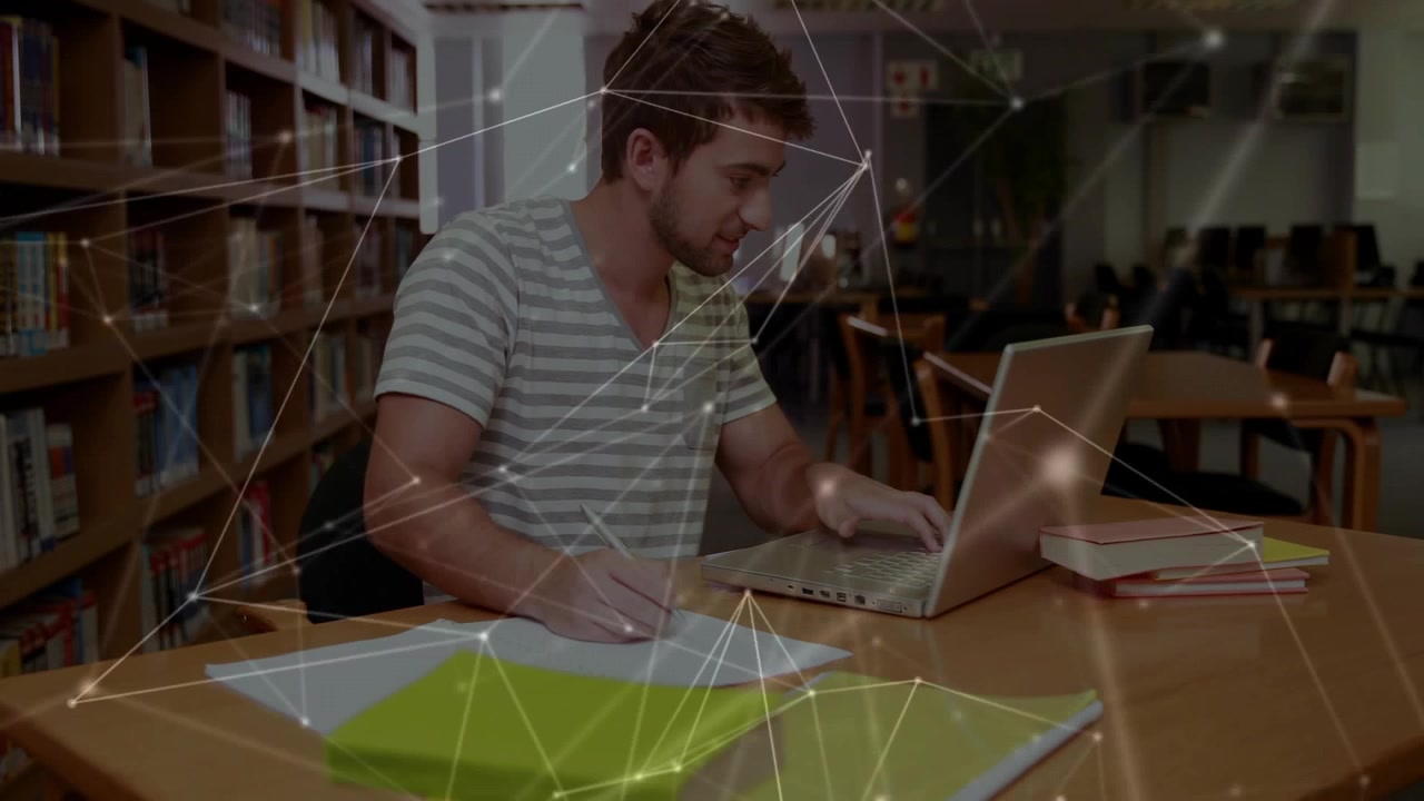 Student writing notes, glancing at laptop then interacting, researching while overlay shifting
