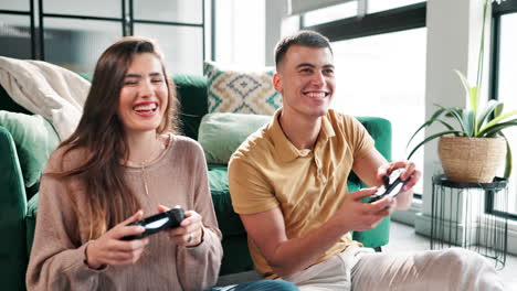 couple laughing and playing video games at home