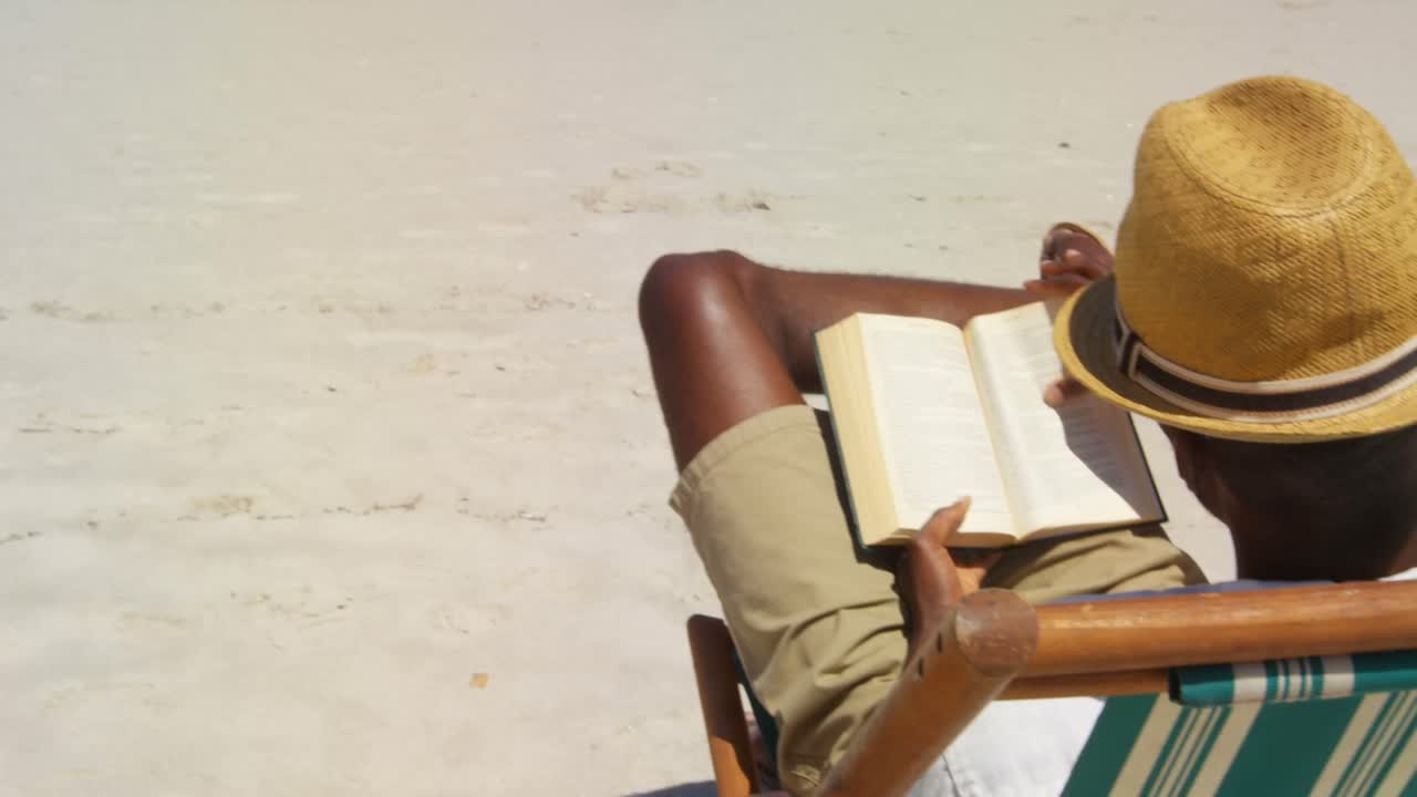 Man reading a book at beach 4k