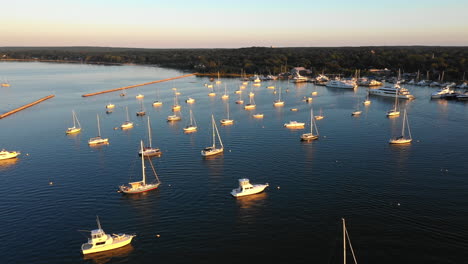 aerial flyover of sailing and fishing boats in the hamptons at sunset