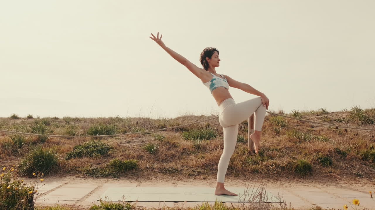 Junge Frau praktiziert Yoga-Balancehaltung im Freien