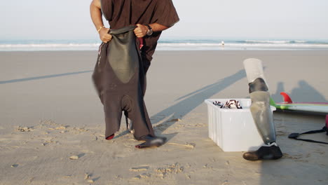 slow motion of a male surfer with artificial leg wearing wetsuit on the beach