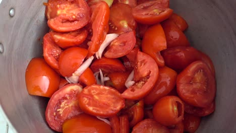 Plano-De-Muñeca-De-Una-Olla-Llena-De-Tomates-Y-Cebollas