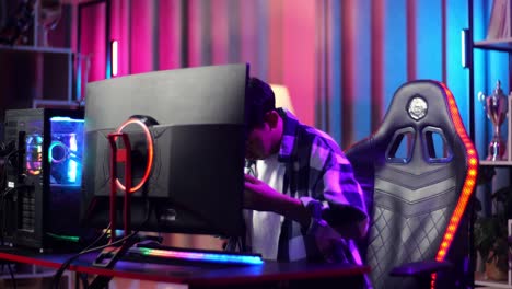 asian teen boy gamer sitting and start play video game on computer