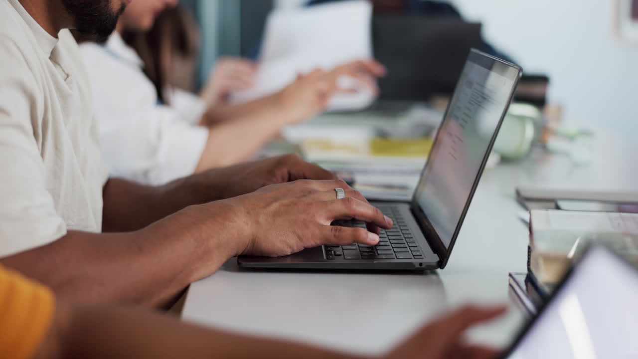 Close-up of Hands Typing on Laptop Keyboard in Office