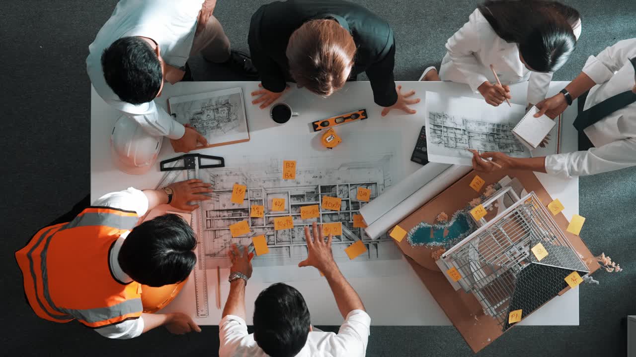 숙련된 엔지니어 팀이 계획을 보면서 대화하는  뷰.