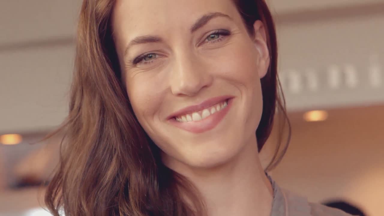 bonita morena sonriendo a la cámara en el bar