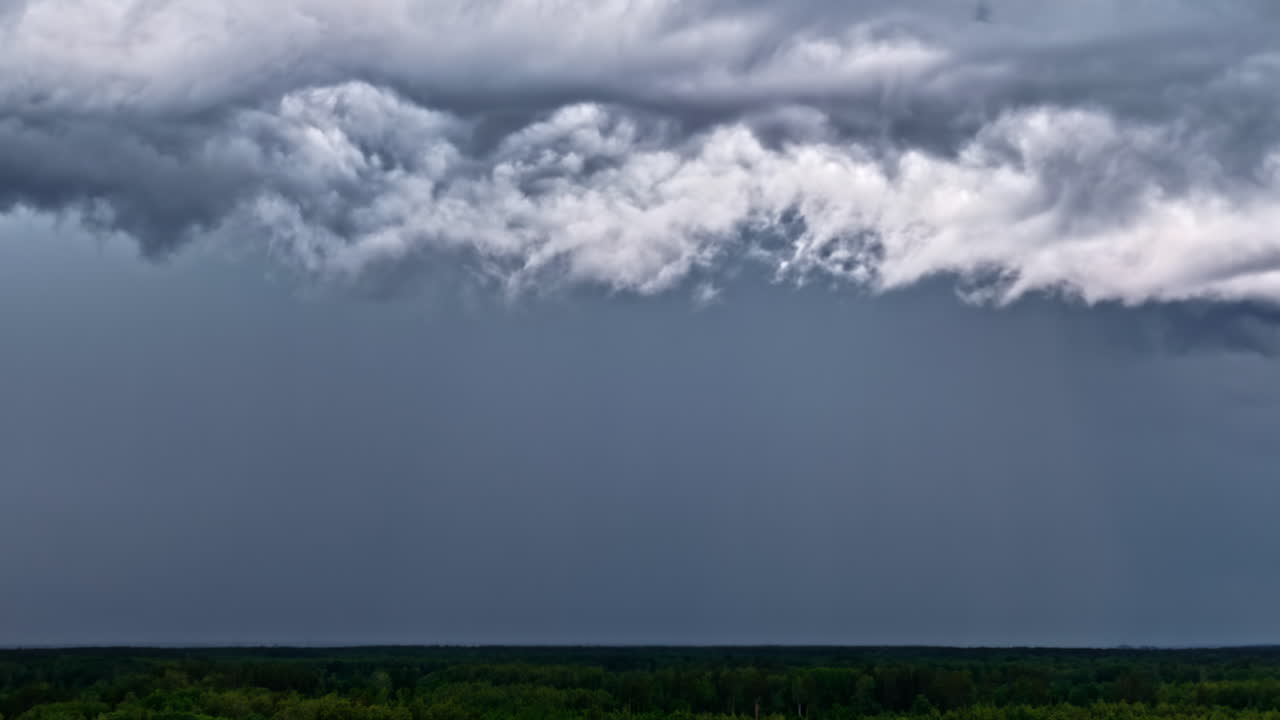 Dark storm clouds rolling in over treetops during approaching thunderstorm