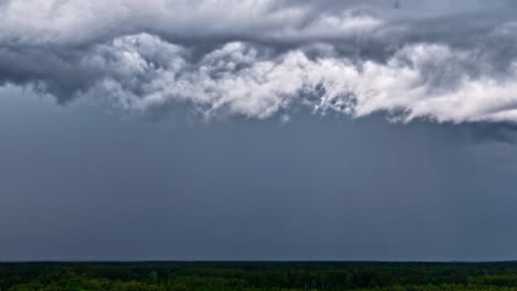 dark storm clouds rolling in over treetops during approaching thunderstorm