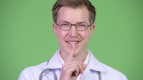 man doctor with finger on lips