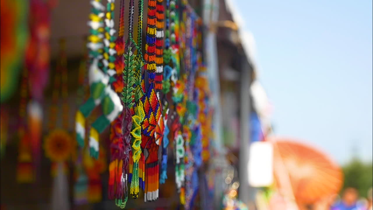 Huichol Traditional Mexican art. Beaded necklaces and bracelets, other jewelry shine in the sun on a summer day. Pictured at a local street fair for artisans to share and sell their works.