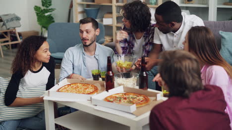 amigos disfrutando de pizza y bebidas en casa