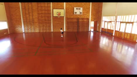 boy playing basketball in court