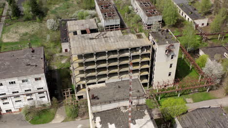 old industrial edifices. ancient manufactory with ruined buildings in abandoned zone in springtime. camera rising up.