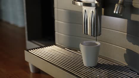 café siendo vertido en una taza por una cafetera