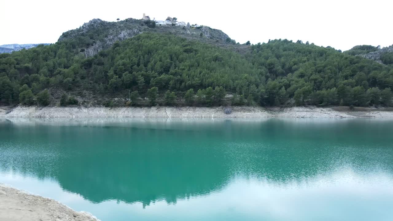 Mountain Lake with Turquoise Water and Village on Hill